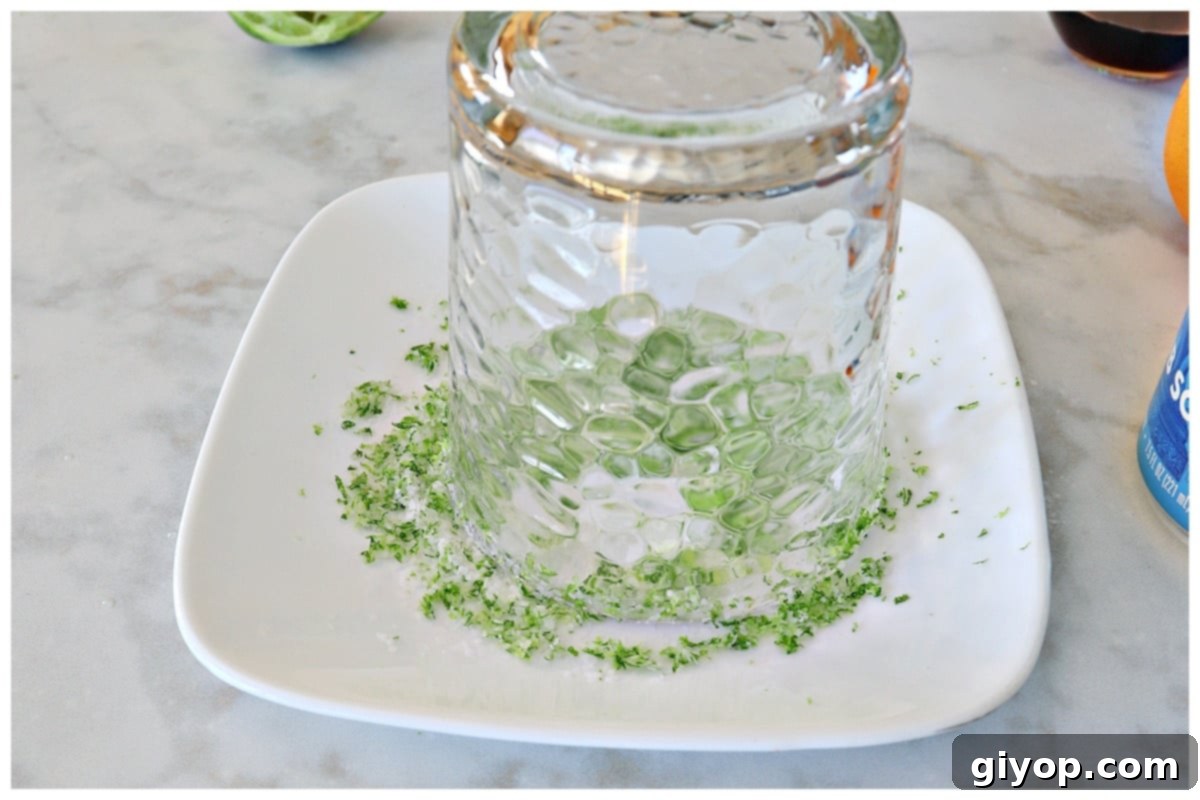 A cup inverted upside down on a plate of salt and lime zest.