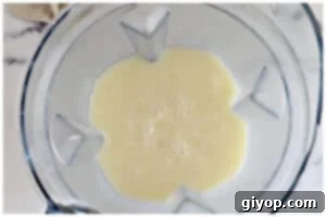 Blended pina colada ingredients creating a smooth, white mixture.