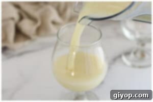 Pouring pina colada into glasses, ready for serving.