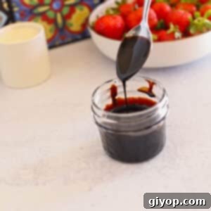 A jar of balsamic glaze with a spoon.