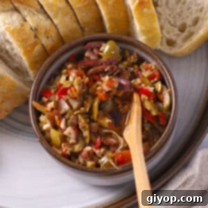 Olive salad in a small bowl with toast on the side.