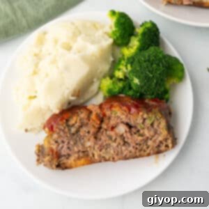 Homestyle Cracker Barrel Meatloaf 2 An overhead image of a slice of meatloaf on a dinner plate with mashed potatoes.