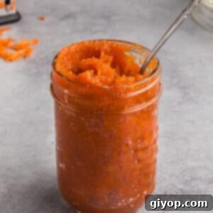 A jar of carrot jam with a spoon in it.