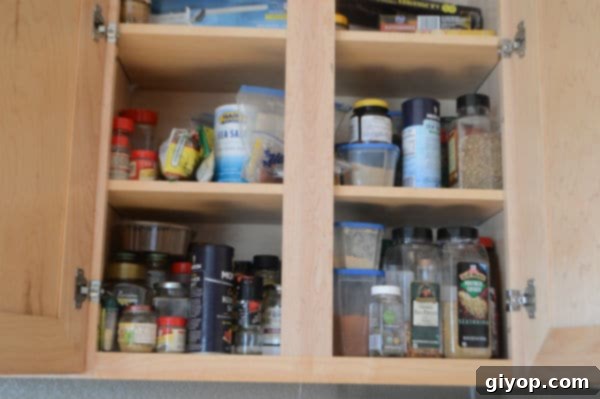 Spice Cabinet Organization Hacks 2 Overloaded and disorganized kitchen spice cabinet before organization