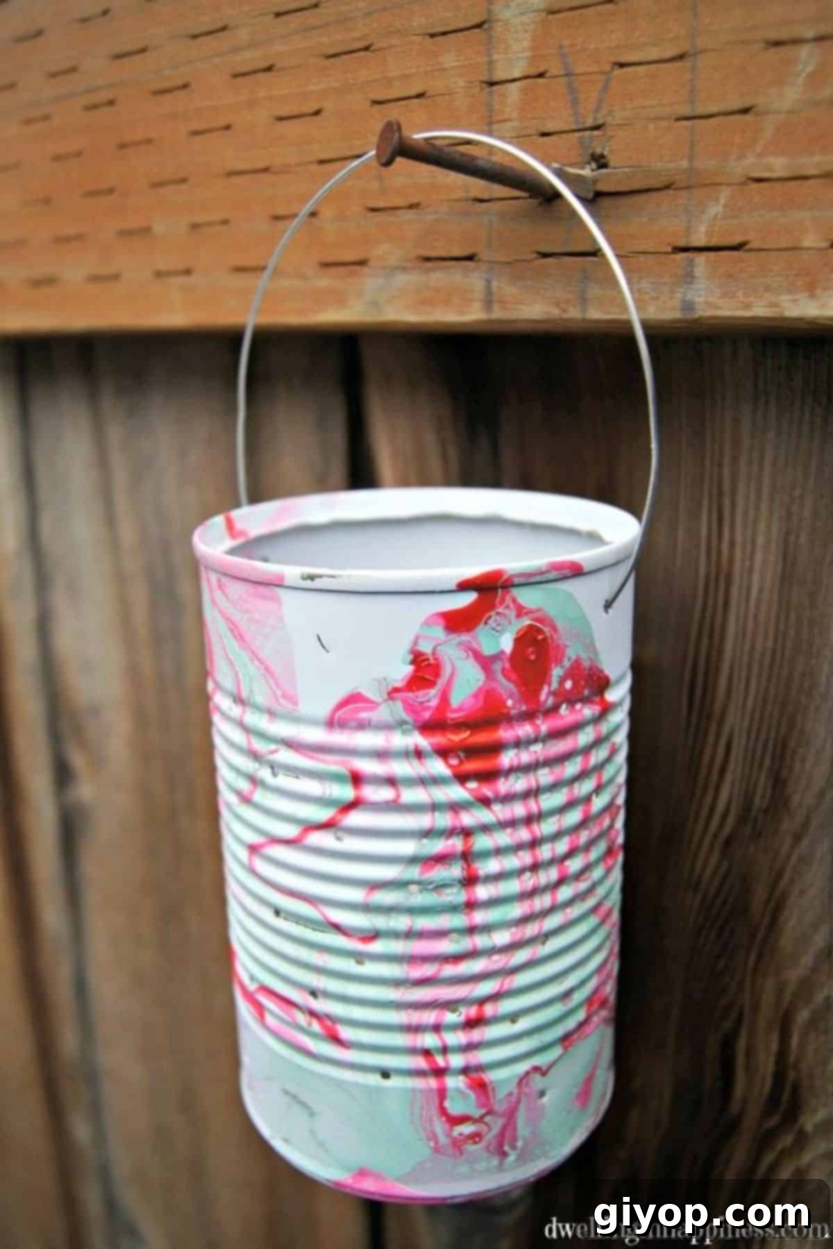 A charming DIY lantern for kids, crafted with care, hanging playfully on a rustic wooden fence, ready to illuminate a festive evening.