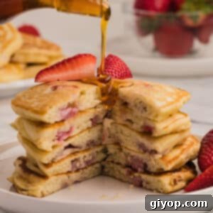 Strawberry Cloud Stacks 2 A stack of pancakes cut to show texture with syrup poured on top.