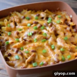 Creamy Chicken Enchilada Pasta 2 Chicken enchilada pasta casserole topped with melted cheese.