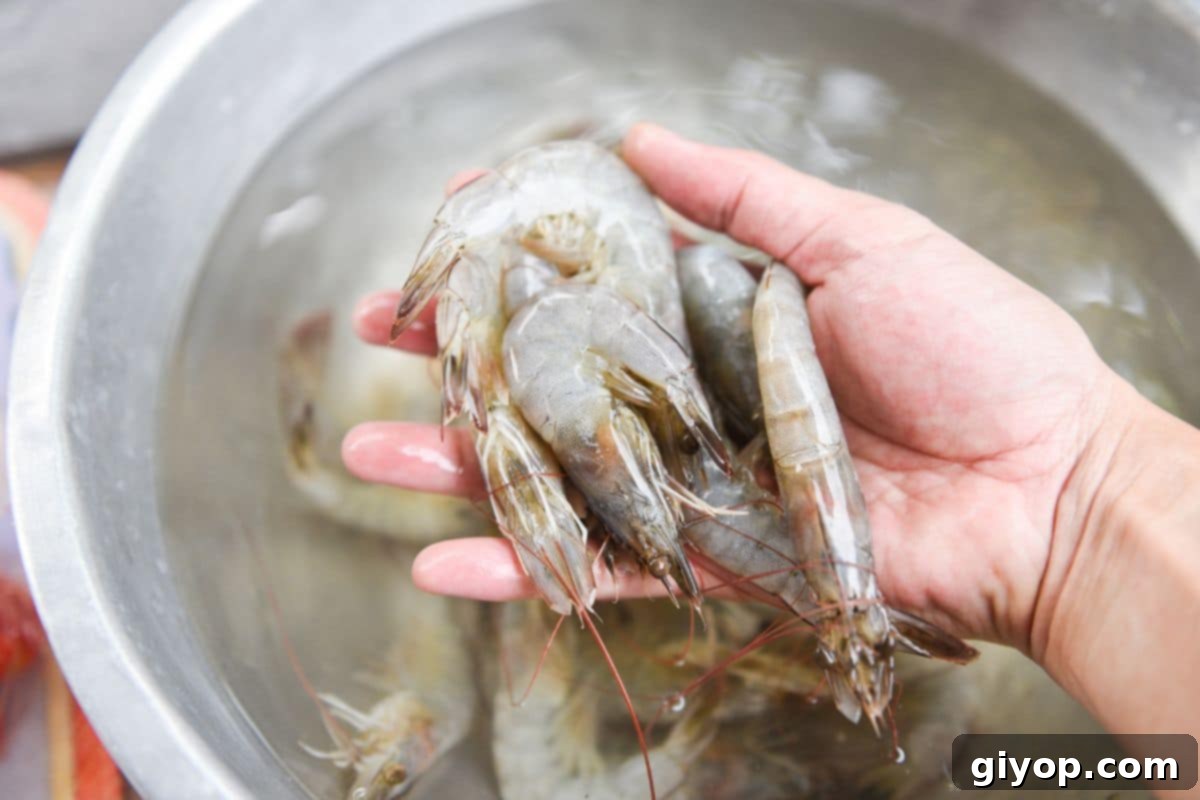 Shrimp Made Simple 3 A person cleaning shrimp in bowl of water.