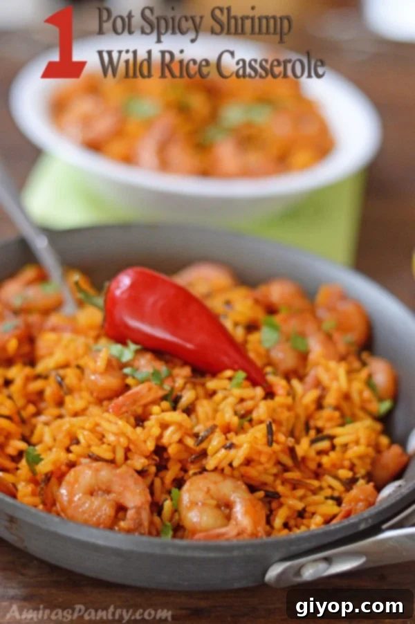A dish is filled in food, with yellow Rice and spicy shrimp