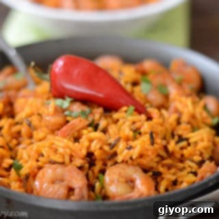 A dish is filled in food, with yellow Rice and spicy shrimp