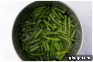Zesty Italian Potato Salad 7 Green beans boiling in a pot.