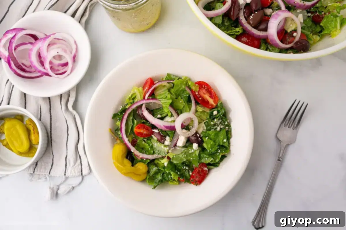 Overhead image of a table with bowls of Panera Greek salad and sliced on the side.