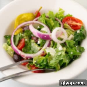 A close up image of a white salad bowl with copycat for Panera Bread Greek salad.