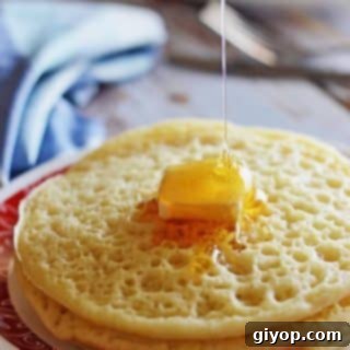 Moroccan Baghrir Thousand Hole Semolina Pancakes 9 A stack of Moroccan Baghrir pancakes with a square of butter on top and drizzling honey over.