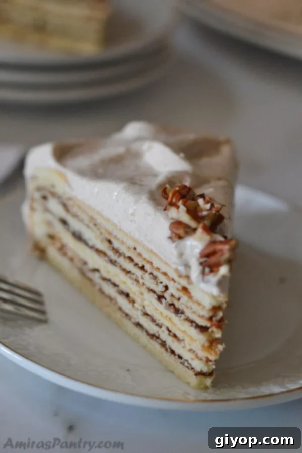 A delicious slice of moist cinnamon layer cake on a white plate, garnished with a light frosting and ready to be enjoyed as a perfect dessert.