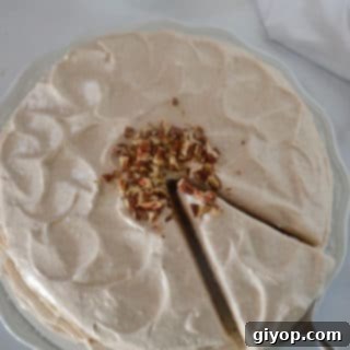 A plate with a delicious slice of cinnamon cake, beautifully frosted and ready to be served, highlighting its moist texture.