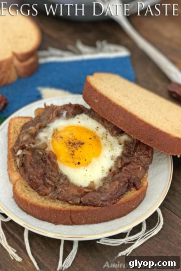 A freshly cooked Egg Agwa dish served with warm, crusty bread, featuring a sunny-side-up egg nestled in a ring of glistening date paste, ready for a delicious meal.