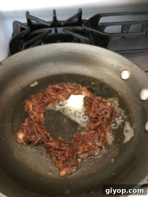 The perfectly formed Agwa ring in the skillet, with the remaining portion of butter meticulously added into the empty center, laying the foundation for the egg to be cooked.