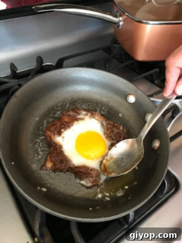 The egg whites are largely set, clearly indicating the progress of cooking, with the vibrant yolk still soft and glistening invitingly in the center of the date paste.