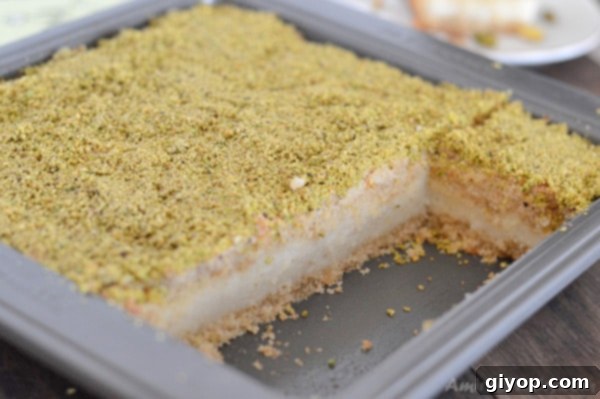 Pistachio-Packed Maamoul with Velvety Ashta 3 A whole pan of freshly baked Ma'mool Mad with Ashta, topped with a generous sprinkle of crushed pistachios, ready to be sliced.