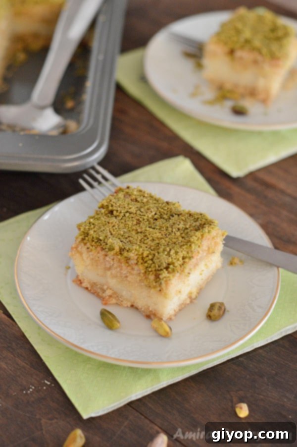 Pistachio-Packed Maamoul with Velvety Ashta 4 A perfectly portioned slice of Ma'mool Mad with creamy Ashta filling, showcasing its layered beauty and pistachio garnish.