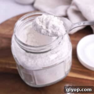 A spoon scooping some bisquick mix off a jar.