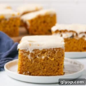 A zoom in image on a pumokin bar on a white plate with cream cheese frosting.
