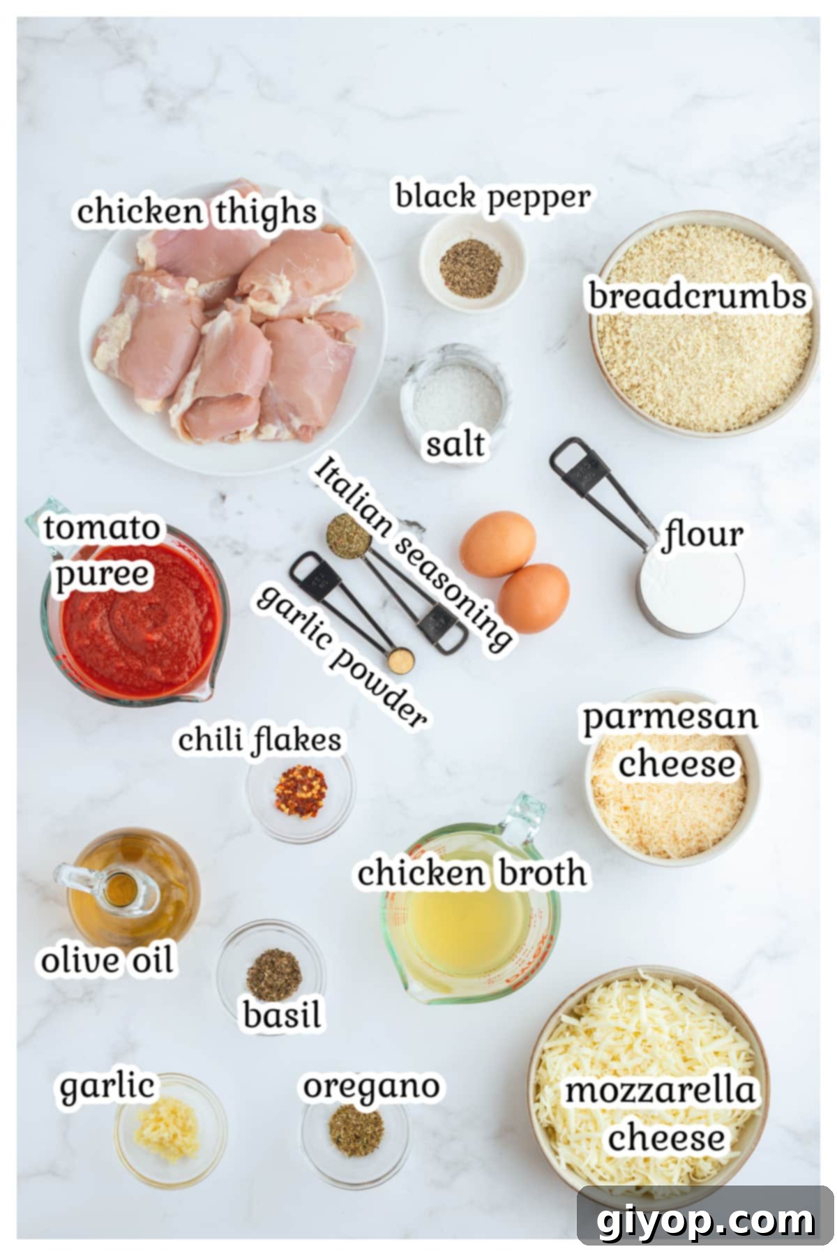 A vibrant flat lay image showcasing all the fresh ingredients needed for Chicken Parmesan Thighs: chicken thighs, eggs, flour, breadcrumbs, cheeses, fresh basil, garlic, tomato puree, and various seasonings.