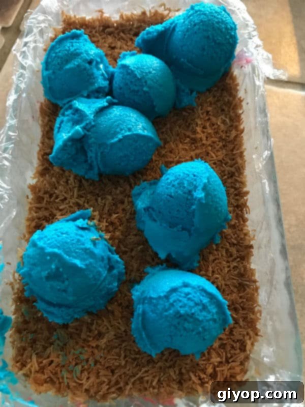 Tricolor Ice Cream Knafeh Delight 11 A mixture of knafeh and blue icecream in a glass pan, completing the patriotic layers