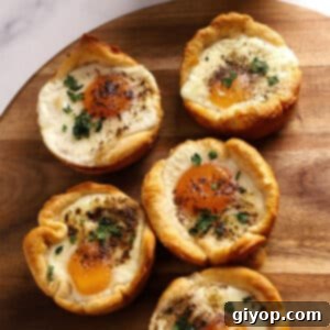 Biscuits with eggs in the middle on a wooden board.