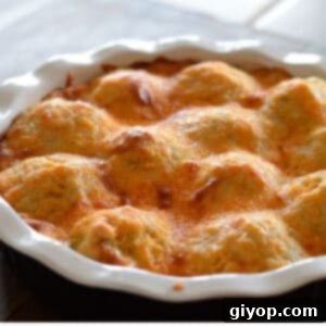 A baking dish with baked mashed potato casserole showing the top golden melted cheese.