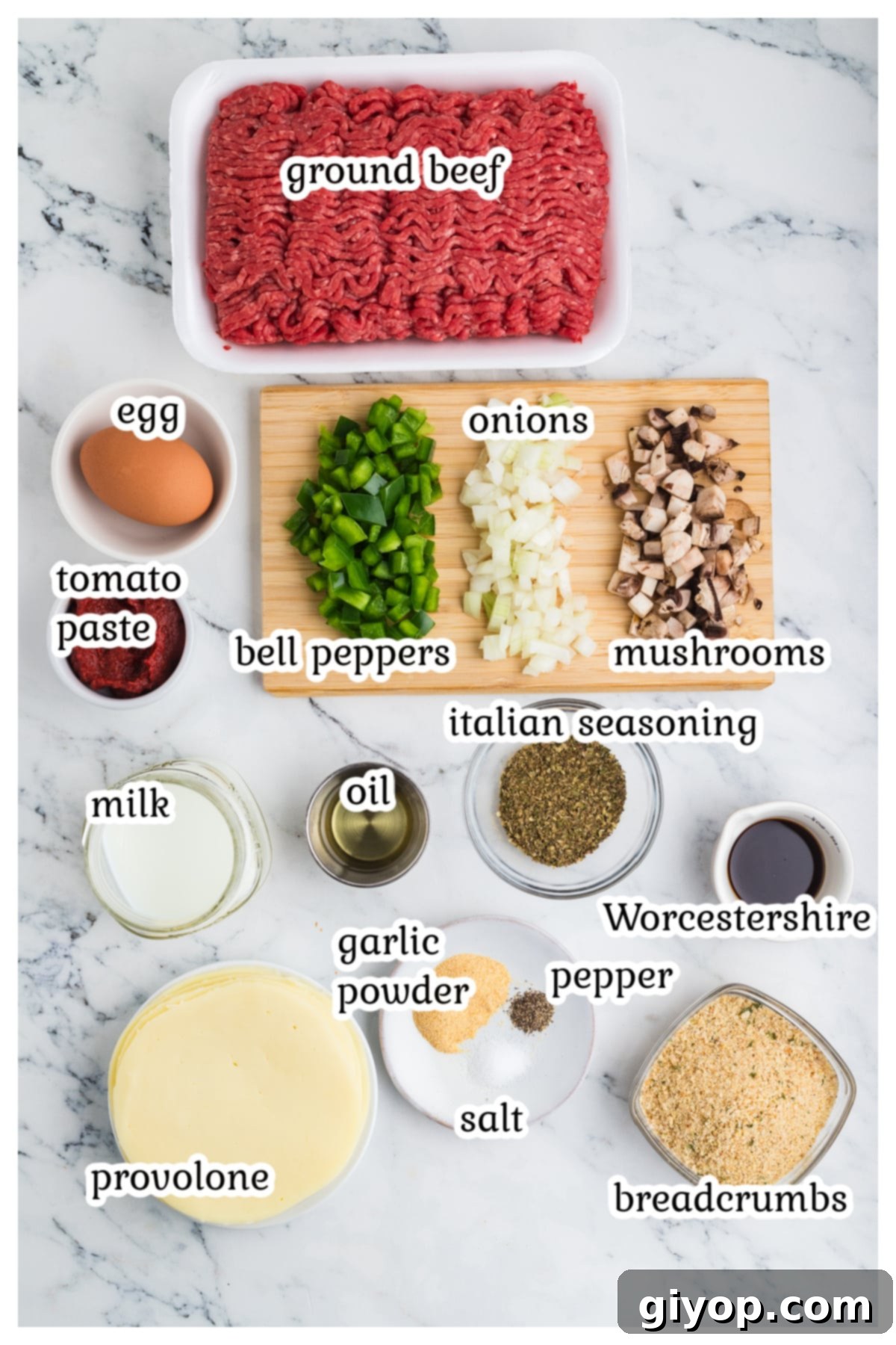 A curated selection of fresh ingredients including bell peppers, onions, mushrooms, ground beef, and various seasonings, neatly arranged on a kitchen countertop, ready for making Philly Cheesesteak Meatloaf.