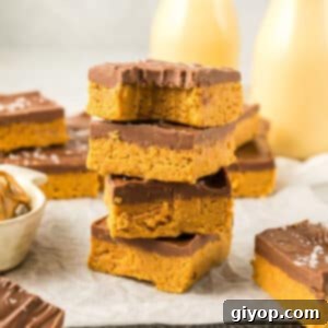 A stack of peanut butter bars with a bite taken from one, showcasing the layers.