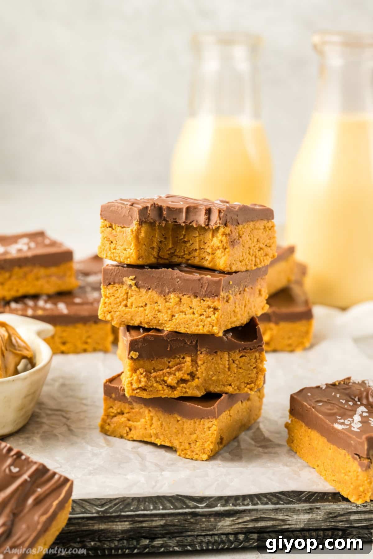 No bake peanut butter bars stacked on top of each other, one with a bite taken to show the smooth texture.