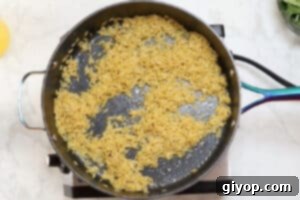 Dry orzo pasta toasting in butter in a large pot until golden.