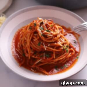 Spaghetti in a big bowl garnished with fresh parsley.