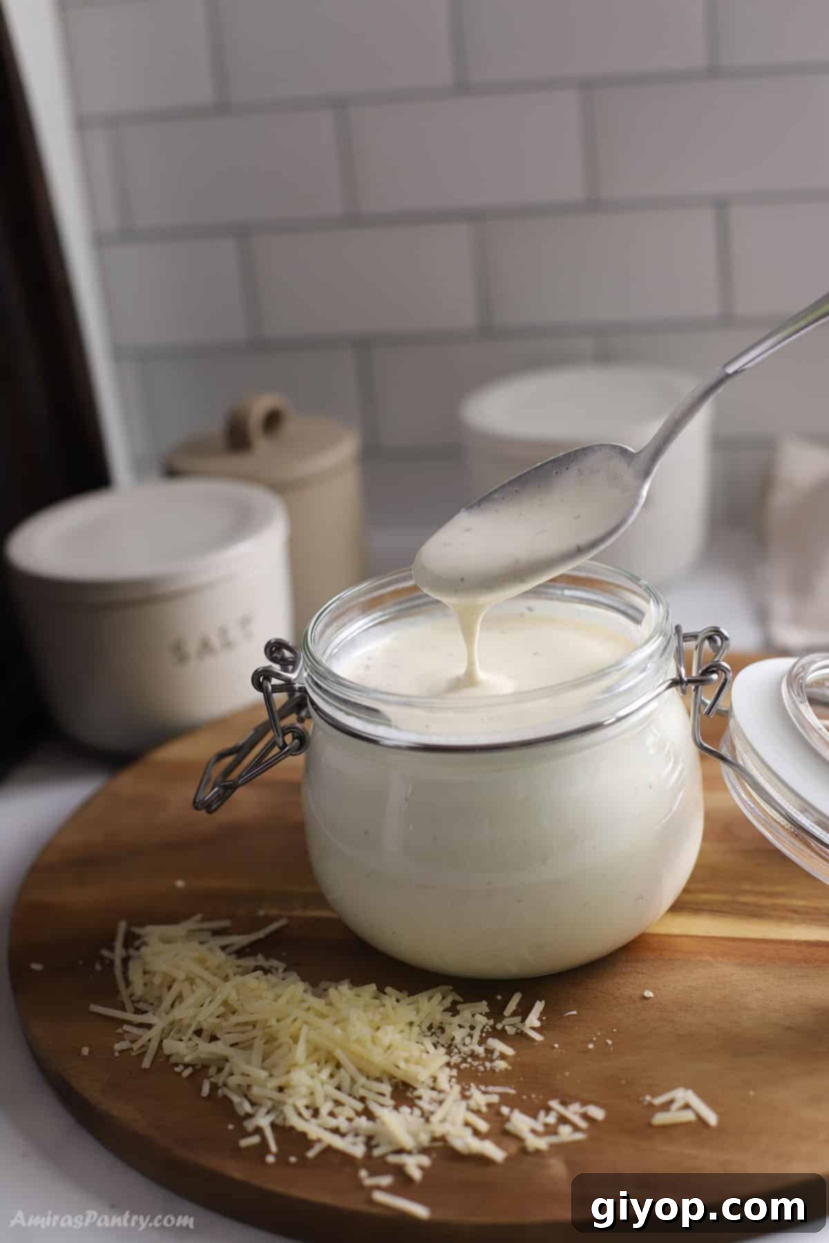 A spoon scooping creamy Alfredo sauce made with half and half from a jar, highlighting its rich texture and appetizing appearance.