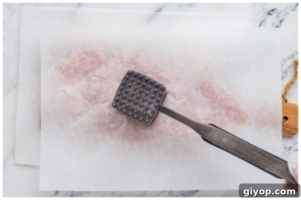 Sun-Kissed Caprese Chicken Sandwich 5 Chicken breast pounded in between parchment papers for even thickness.