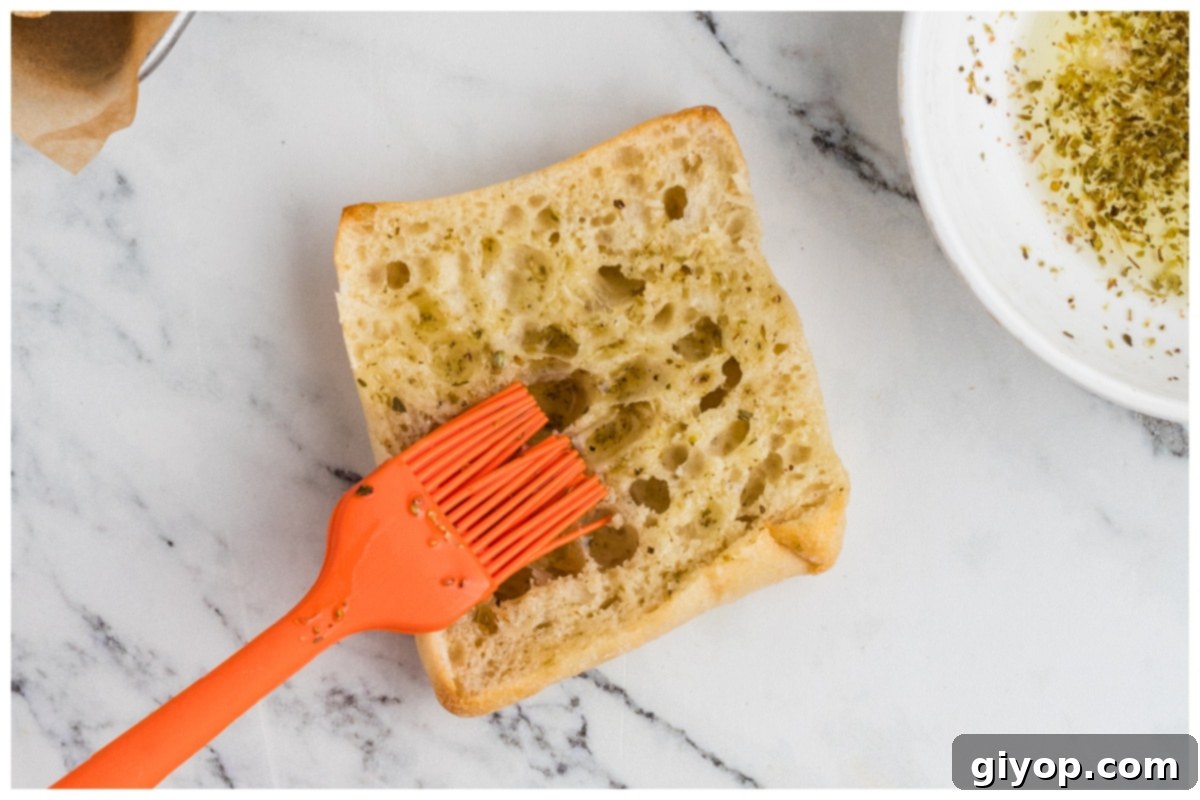 Sun-Kissed Caprese Chicken Sandwich 8 Brushing Ciabatta bread pieces with the reserved marinade mixture.