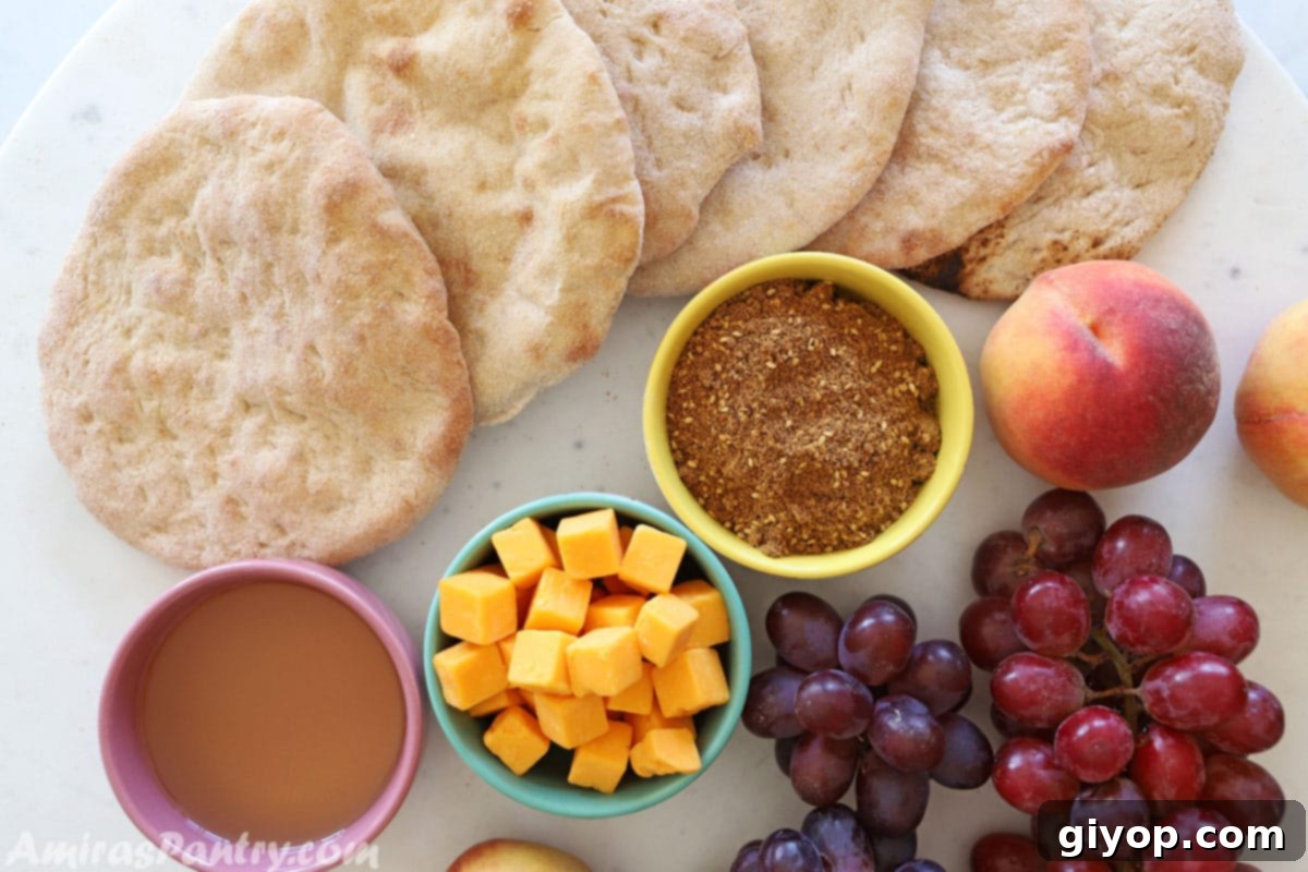 A vibrant breakfast table featuring freshly baked Taboon bread, a bowl of za'atar, olive oil, an assortment of cheeses, and fresh fruits, creating a delicious spread.
