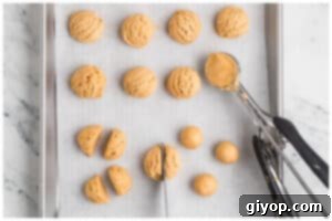 A cookies sheet with peanut butter balls.