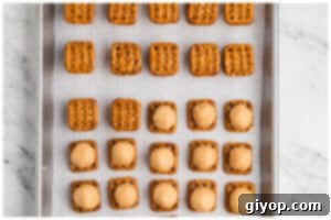 A cookie sheet with peanut butter pretzel sandwiches.