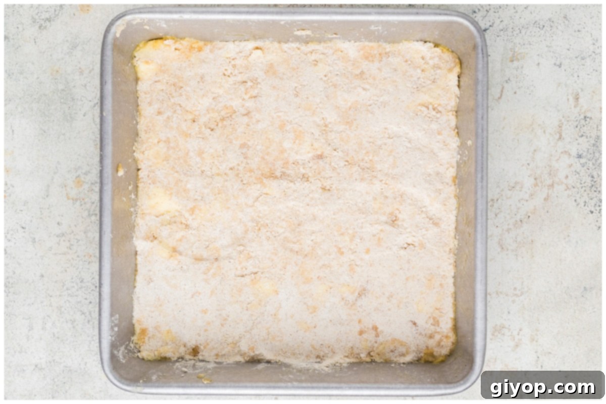 Decadent Salted Caramel Apple Pie Bars 8 An 8x8 inch light-colored baking pan with the pressed shortbread crust forming a neat, even base, ready for its initial bake.