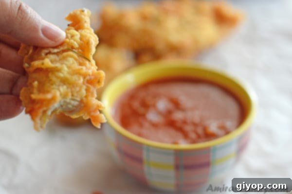 Freshly fried golden chicken strips with a side of vibrant salsa dip.