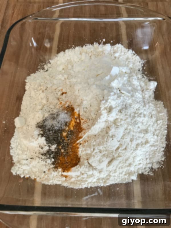 Dry ingredients for the crispy coating being mixed in a separate glass bowl.