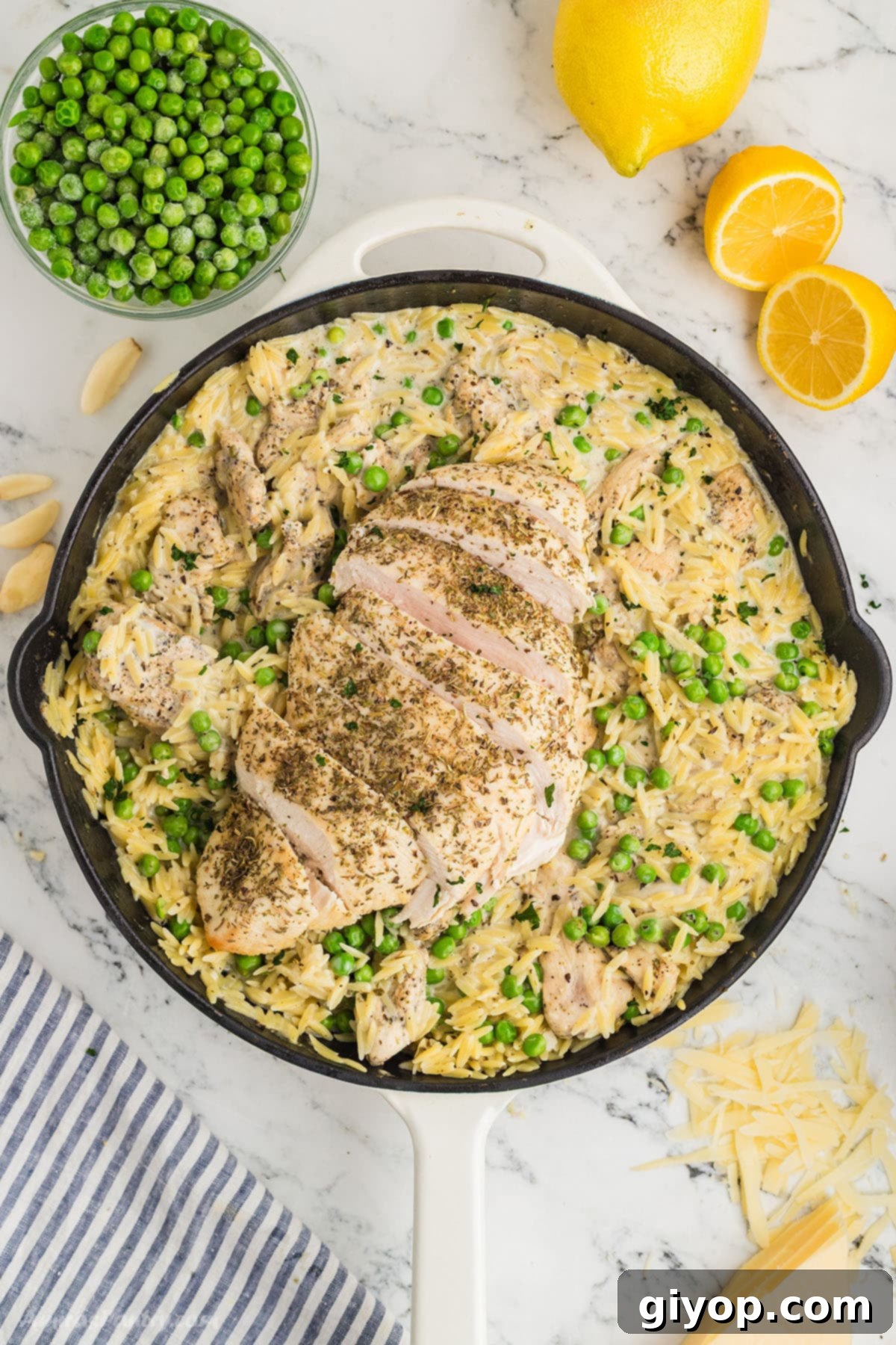 Bright Lemon Chicken Orzo 2 An overhead image of a skillet with bright, creamy lemon chicken orzo garnished with fresh parsley.