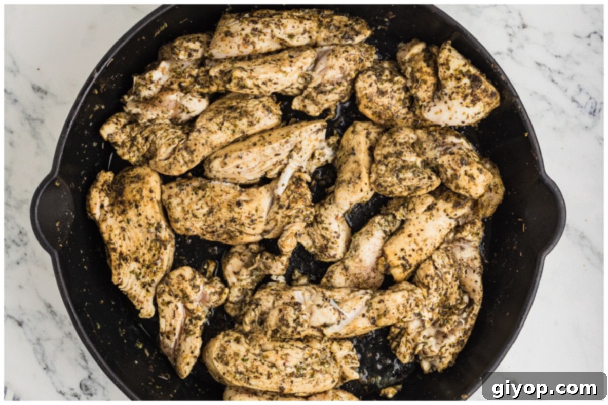 Bright Lemon Chicken Orzo 7 Perfectly seared and golden-brown seasoned chicken strips cooking in a large skillet, adding depth of flavor.