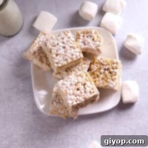 A delectable stack of Rice Krispie treats arranged on a clean white plate, highlighting their inviting texture and golden hue.