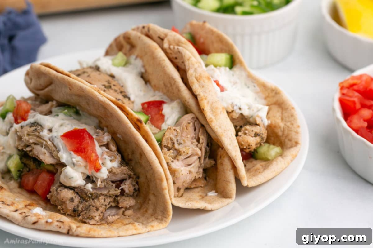 Set-It-and-Forget-It Chicken Gyros 3 Close-up view of a delicious Slow Cooker Chicken Gyros wrap, showcasing the tender chicken, fresh toppings, and creamy tzatziki.