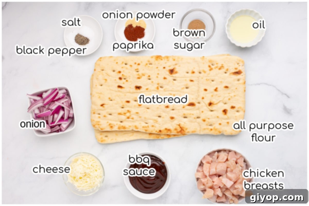 Ingredients for the chicken flatbread pizza laid out on a marble surface, including chicken, spices, flatbread, sauce, and cheese.